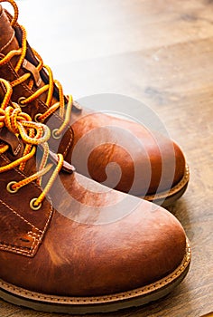 Leather boots shoes on the brown wooden table background.with copy space.