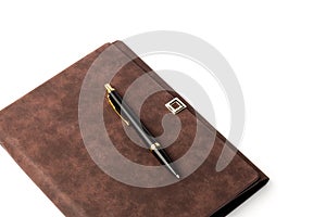 Leather-bound business notebook with a Parker pen on a white background. Business concept