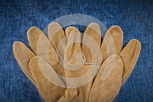 Leather brown construction gloves on scratched metallic surface