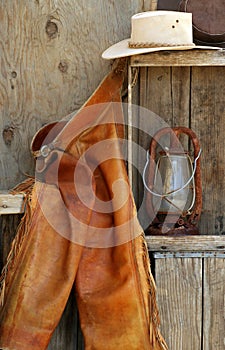 Leather chaps, cowboy hats, lantern on shelf