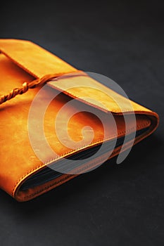 The leather cover of the album is made of brown handmade genuine leather on a black background. Elements of a leather product