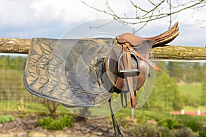 Leather cowboy saddle hanging on the railing