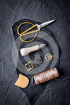 Leather craft instruments on dark background top view mock up