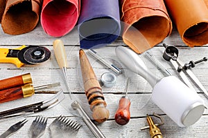 Leather craft tools and utensils on wooden background