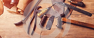 Leather craft workshop. Shoemaker`s work desk. Tools and leather at cobbler workplace