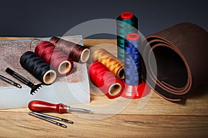 Leather crafting tools. Set of leather craftman tools with colorful threads photo