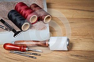 Leather crafting tools. Set of leather craftman tools with colorful threads photo