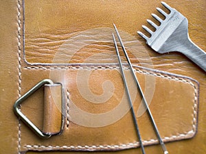 Leather craftsman tools on tan leather. sewing line. Leather craft and handmade concept.