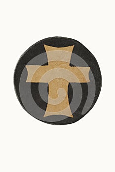 Leather cross on a circular medallion representing the world.
