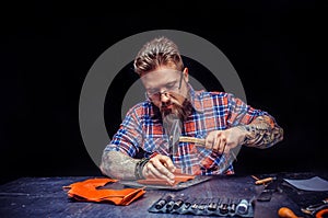 Leather Currier at work on his new leather product in his leather studio