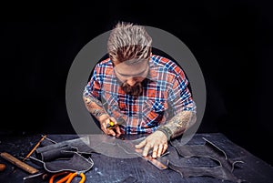 Leather cutter working with leatherwork in his place of work