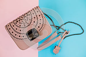 A leather designer handbag, floating against a colorful background, vivid blue and pink colours.Luxury light pink