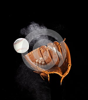 Leather glove mitt receive hit baseball ball and dust soil explode in air. Baseball ball throw and hit to center of mitt glove.