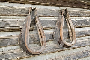 Leather horse collars on log cabin wall