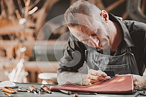 Leather maker artist handcraft working at own workshop small studio made by order masterwork piece photo