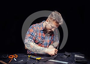 Leather man processing a leather workpiece at the workplace