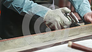 A leather master is dying leather belt edges with fire. Working process of the leather belt in the leather workshop.