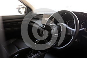 Leather multifunction steering wheel in the cabin of a premium car. Installed under the steering wheel control switches additional