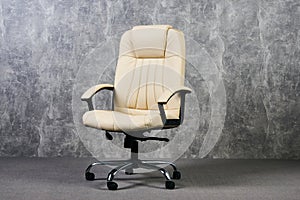 Leather office chair in empty room with gray texture wall background