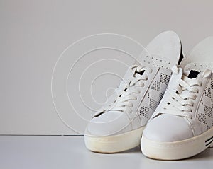 Leather orthopedic insoles and white sport shoes on white background.