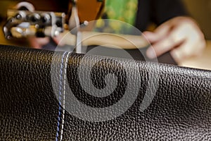 Leather Piece in Foreground with Blue and White Stitching on a Commercial Sewing Machine