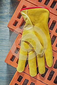 Leather protective gloves red bricks on wooden board constructio