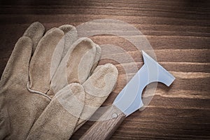 Leather safety construction gloves and surfacer on wooden board photo