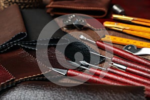 Leather samples and tools on brown table, closeup