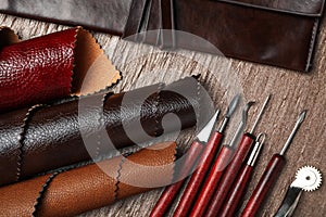 Leather samples and tools on brown table, flat lay