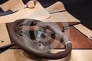 Leather steering wheel brown color in the process of stitching with a bright contrast seam and white central point on the top in