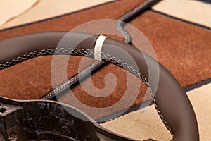 Leather steering wheel brown color in the process of stitching with a bright contrast seam and white central point on the top in