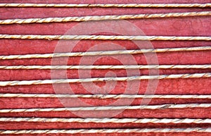 Leather string with red paint on wooden background. Leather drum string background