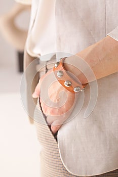 Piel densamente naranja pulsera sobre el una mujer mano detallado en blanco muro 