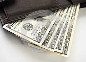 Leather wallet full of money on white background - fan of one hundred US banknotes with president Franklin portrait.