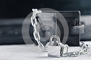 Leather wallet with lock and chain on background computer. Ð¡oncept of protecting electronic money and safety personal finances. S