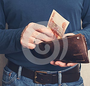 Leather wallet with money in male hands. Purse with roubles  in male hands
