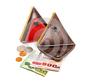 Leather wallets with thai banknotes and coins on white background.