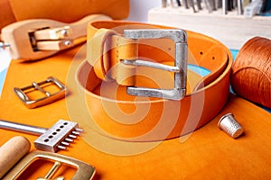 Leather working or Leather craft. Orange tanned leather on leather craftman`s work desk . Working tools on a work table