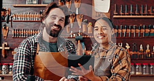 Leather workshop, portrait of man and woman with tablet, discussion and tools for manufacturing of unique textile