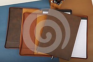 Leather Zipper Portfolio. Concept shot, top view, flap portfolio in brown colors and leather pen. Custom background flap portfolio