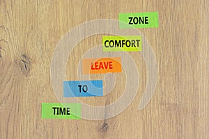 Leave comfort zone symbol. Concept words Time to leave comfort zone on colored paper. Beautiful wooden table wooden background.