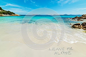 Leave me alone written on a beach