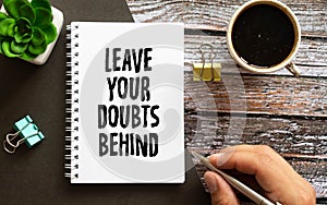 Leave your doubts behind - handwriting on a napkin with a cup of espresso coffee