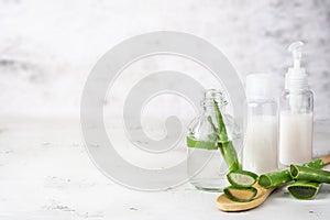 Leaves of Aloe vera plant and bottles with beauty products. Natural ingredient for herbal cosmetics, cosmetology, dermatology,