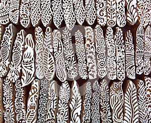 Leaves, flowers, patterns on wooden surface of mold blocks for traditional printing textile. Background from India