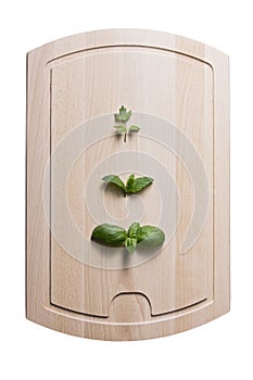 Leaves of lovage mint and basil on wooden board