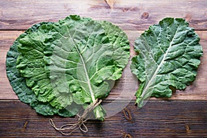 Leaves of rastan  Collard greens, collards   on rustic table. Free space for text