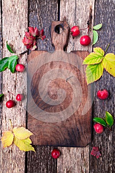 Leaves and small apple around empty cutting board