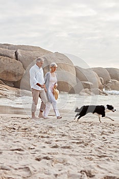 Leaving their footprints in the sand. Full length shot of an affectionate middle aged couple walking hand in hand with