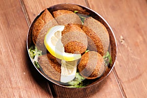 Lebanese Kebbeh, kibbe, kebbah, kibbeh and kebba served in dish isolated on background top view of hot mezza photo